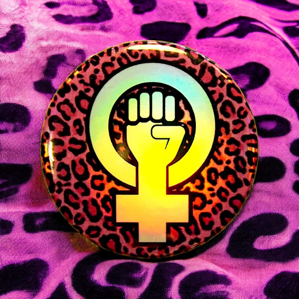 Badge holographique logo féministe sur fond léopard rose