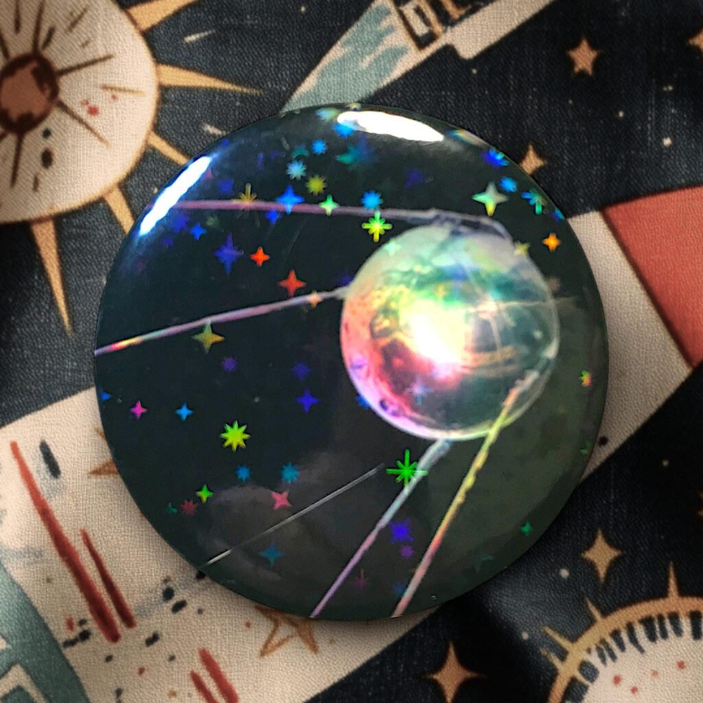 Badge Sputnik avec effet d'étoiles holographique