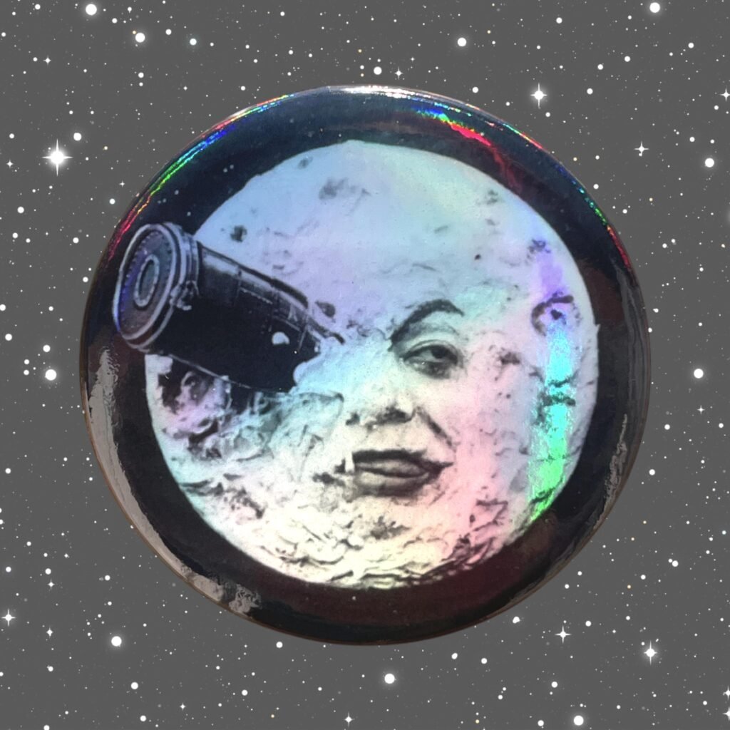 Badge Le Voyage dans la Lune Holographique – Méliès 1902, Lune Iconique borgne & Fusée, 44 mm Métal, Cinéma Pionnier,